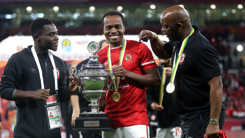 Percy Tau of Al Ahly celebrate with the Champions League trophy while Pitso Mosimane looks on 