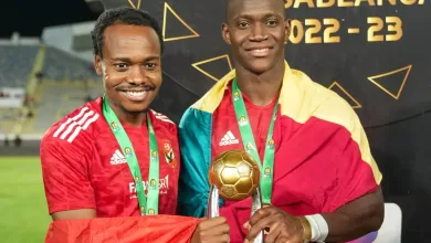 Percy Tau with the CAF Champions League trophy and his Al Ahly teammate